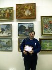 Alexey Akindinov with a medal «Talent and Calling» and the certificate to it against his pictures at the exhibition «Peacemakers». CHA. Moscow. 29.12.09.