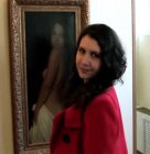Ольга Лёвина на фоне своего портрета работы Андрея Миронова.
